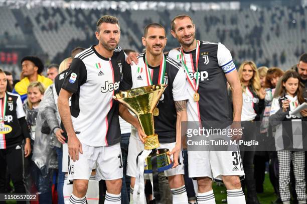 Andrea Barzagli, Leonardo Bonucci and Giorgio Chiellini of Juventus celebrate during the awards ceremony after winning the Serie A Championship...