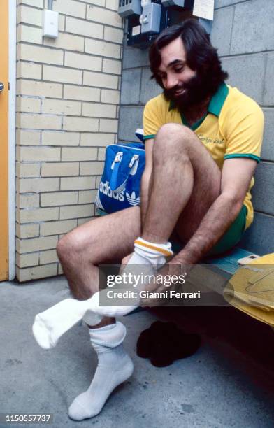 English soccer player George Best as he pulls on a sock in a locker room, Brisbane, Australia, 1983.