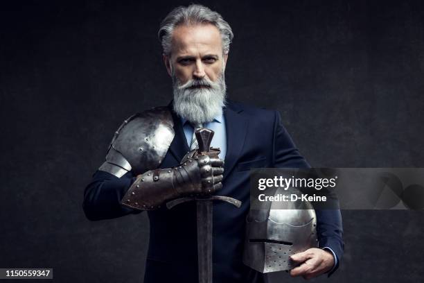 classy dressed senior businessman with knight sword - asset protection stock pictures, royalty-free photos & images