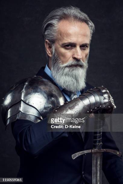 classy dressed senior businessman with knight sword - knight person stock pictures, royalty-free photos & images
