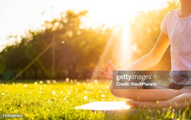 unerkennbares mädchen in yoga-pose - children yoga stock-fotos und bilder