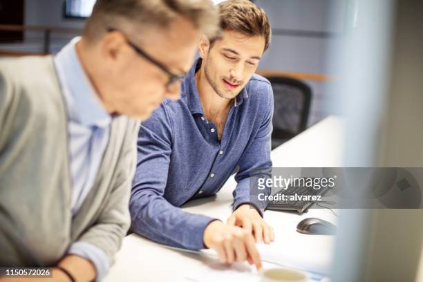 colleagues working over some finance reports - explaining stock pictures, royalty-free photos & images