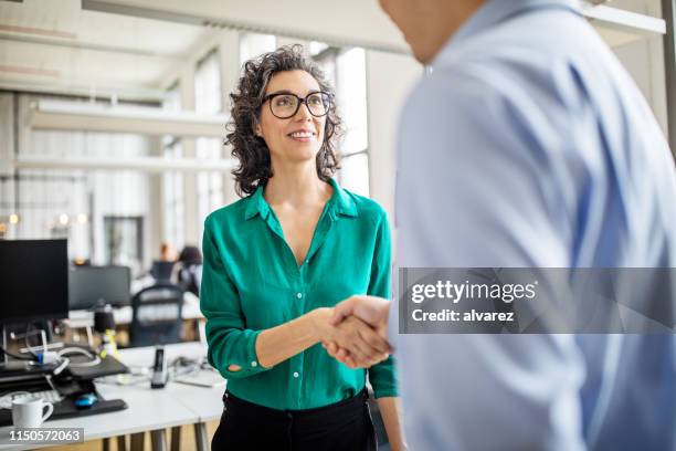 femme d’affaires serrant la main avec un collègue - homme rencontre femme photos et images de collection