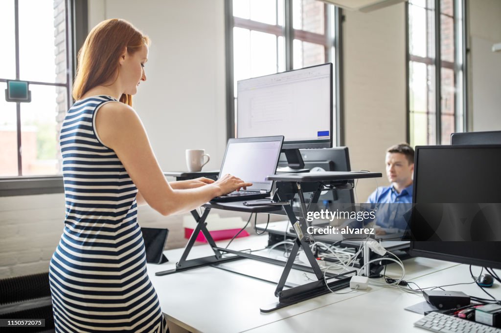 Businesswoman working at ergonomic standing desk