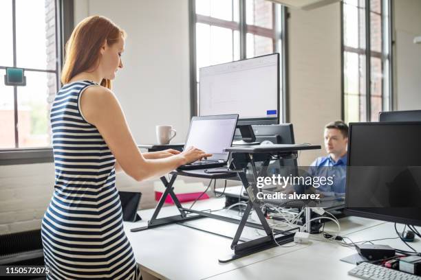 affärs kvinna som arbetar på ergonomiskt stående skriv bord - ergonomics bildbanksfoton och bilder