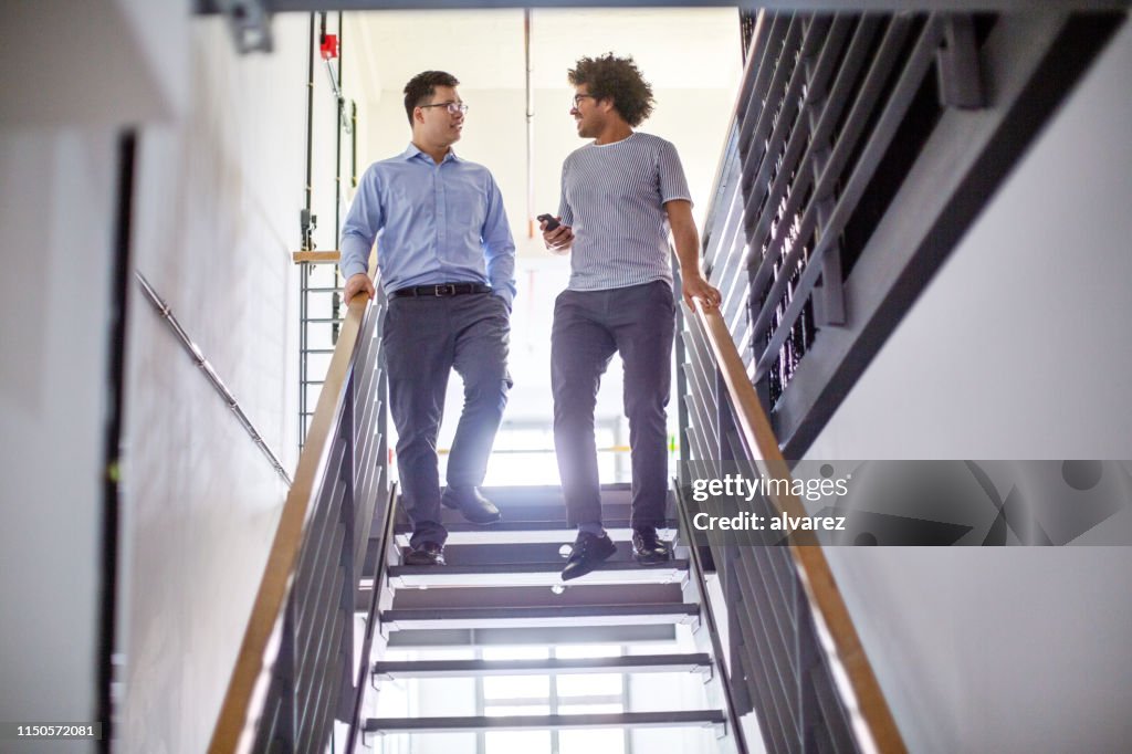 Business partners walking down the stairs and talking