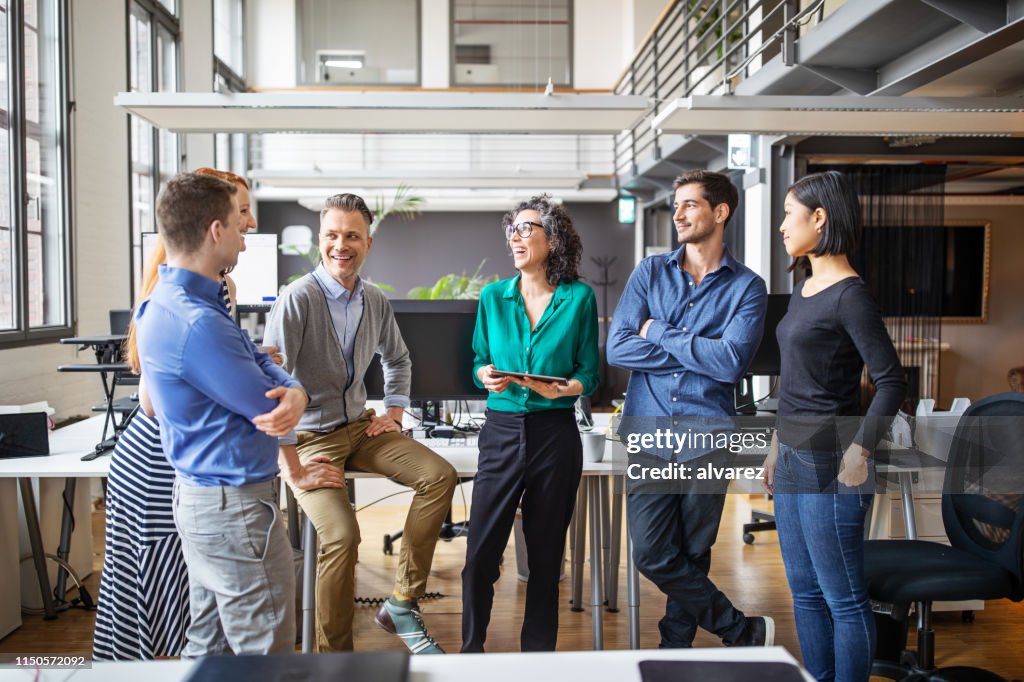 Equipo de negocios feliz teniendo una reunión permanente en la oficina