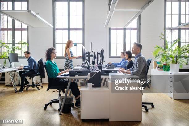 zakenmensen werken bij een modern kantoor - horizontaal stockfoto's en -beelden