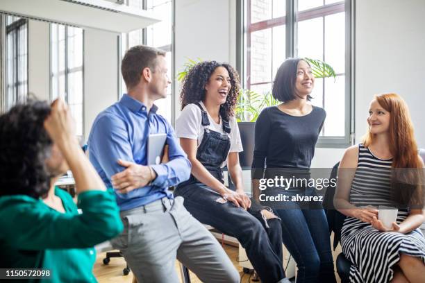 les professionnels riant lors d’une réunion - happy group photos et images de collection