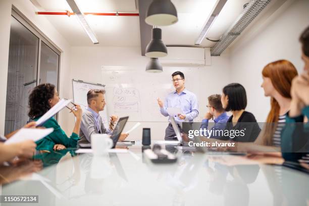 asian businessman giving presentation to colleagues - ai assistant stock pictures, royalty-free photos & images