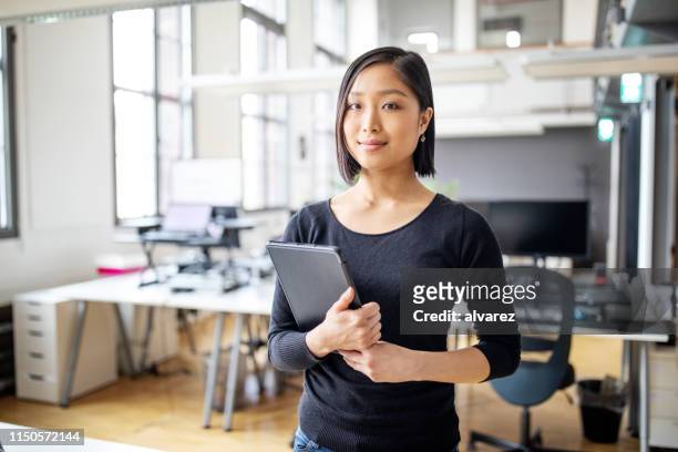 businesswoman in smart casuals standing in office - business casual stock pictures, royalty-free photos & images