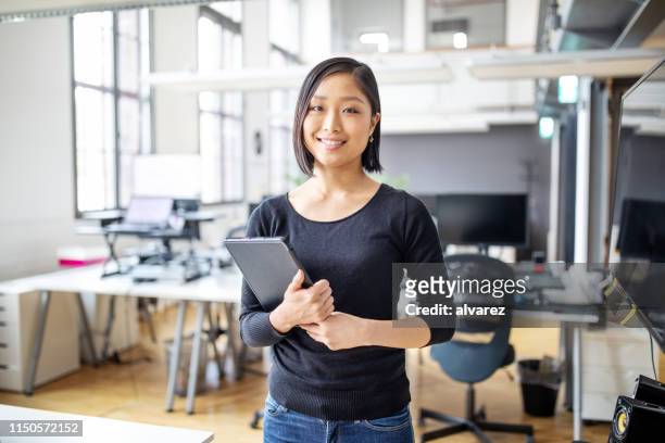 smiling female executive with digital tablet. - smart casual stock pictures, royalty-free photos & images