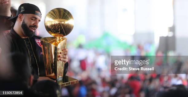 Drake holds the Larry O'Brien NBA Championship Trophy as the Toronto Raptors hold their victory parade after beating the Golden State Warriors in the...