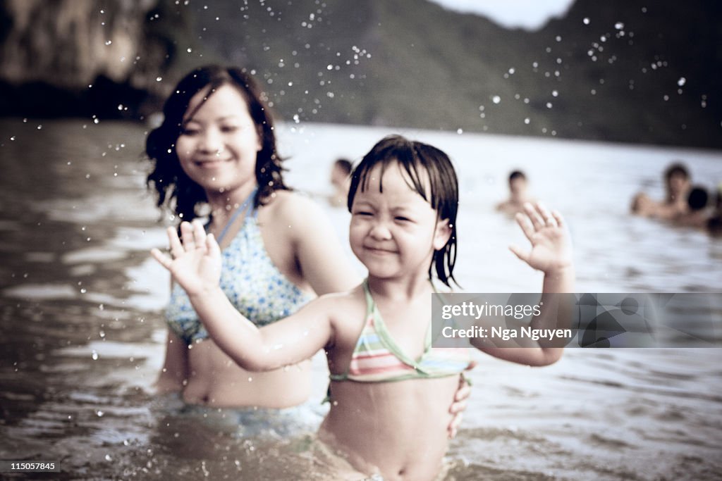 Mother and little daughter having fun at beach