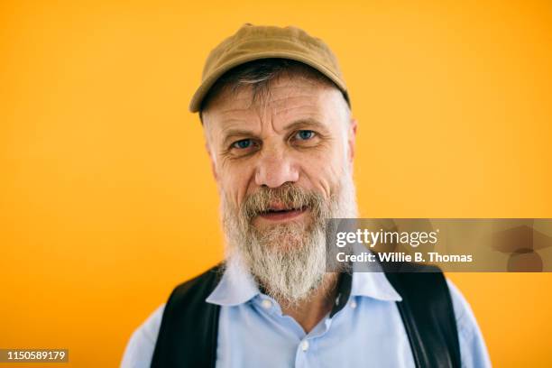 senior gay man on colorful background - portrait orange background stock pictures, royalty-free photos & images