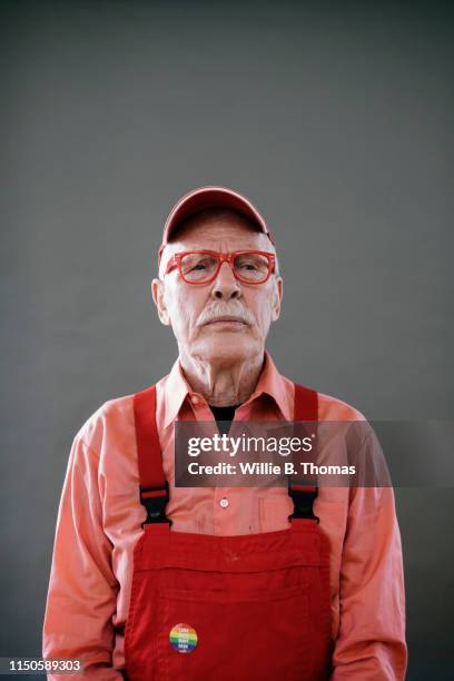 portrait of senior gay man frowning - red jumpsuit stock pictures, royalty-free photos & images