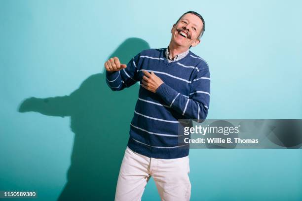 senior gay man dancing - coloured background lachen stock-fotos und bilder