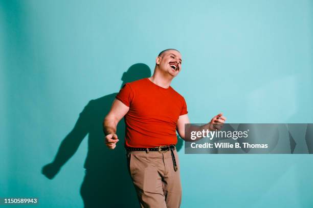 vibrance portrait of man dancing - blue studio stock-fotos und bilder