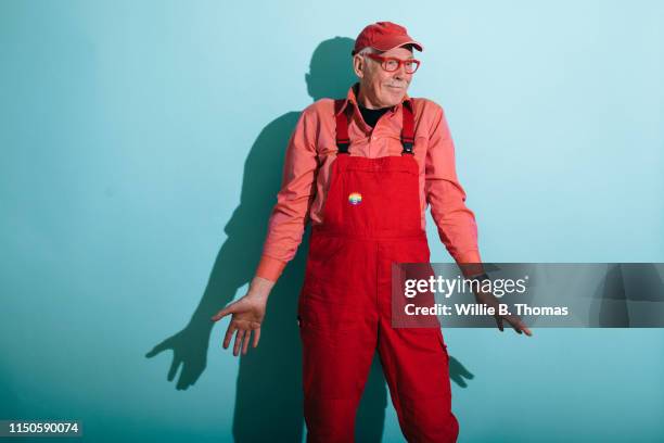 senior gay man in red overalls - coveralls - fotografias e filmes do acervo