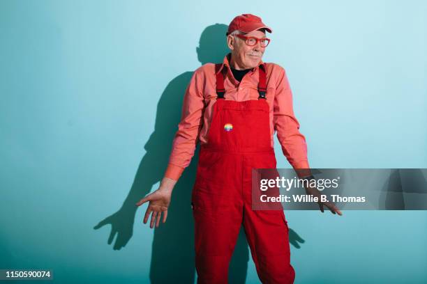 senior gay man in red overalls - 連身工作服 個照片及圖片檔