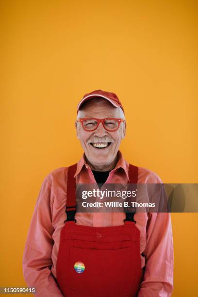 portrait of senior gay man with copyspace - red jumpsuit stock pictures, royalty-free photos & images