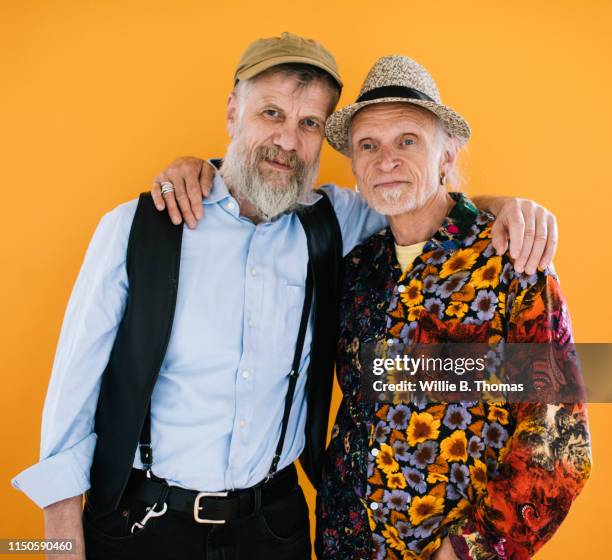 portrait of senior couple looking into camera - arm umlegen stock-fotos und bilder