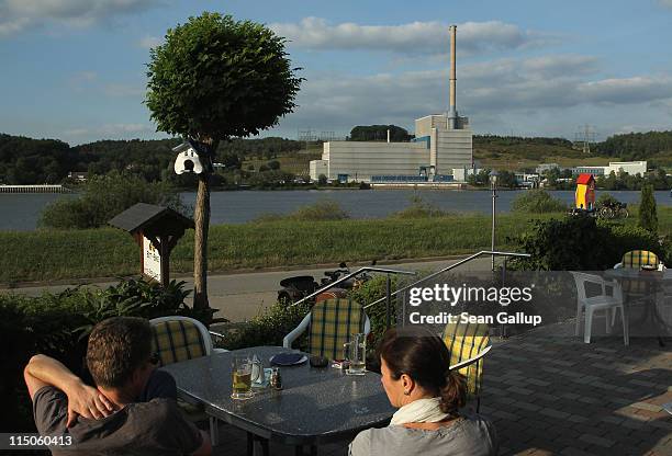 People sit on a restaurant terrace across from the troubled Kruemmel nuclear power plant along the Elbe River on June 2, 2011 in Geesthacht, Germany....