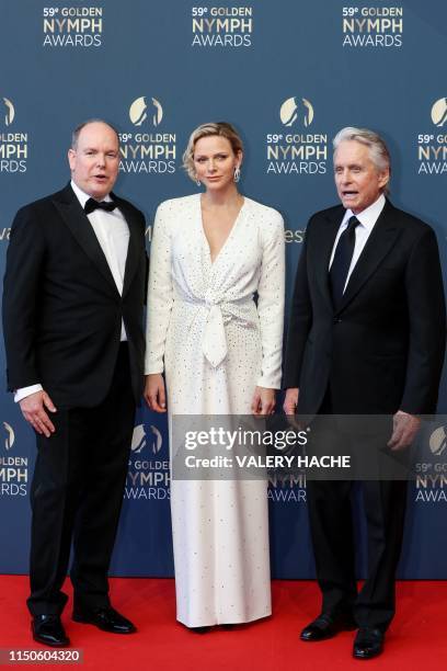 Albert II of Monaco and his wife Charlene of Monaco pose with US actor Michael Douglas who'll receive a Golden Nymph Award for his career, during the...