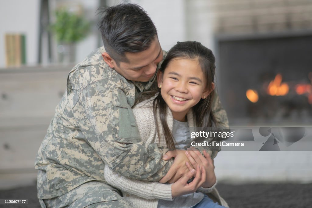 軍事爸爸擁抱他的年輕女兒