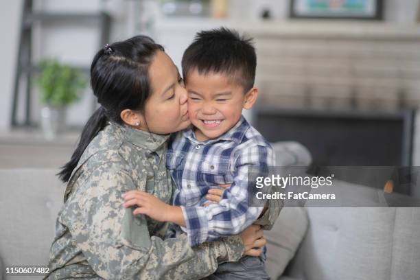 mamma militare che abbraccia suo figlio - filipino family reunion foto e immagini stock
