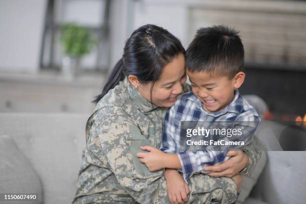 military mom hugging her son - filipino family reunion stock pictures, royalty-free photos & images