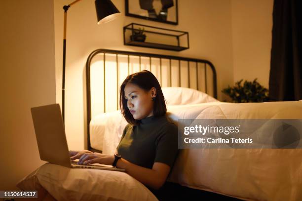 woman working from her laptop at home late at night - working late imagens e fotografias de stock