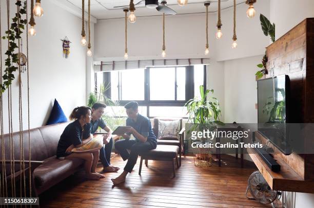 young couple having a financial consultation in their living room - obama meets with minister mentor of singapore stockfoto's en -beelden