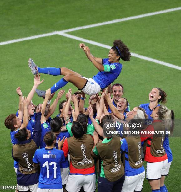 Italy celebrate progressing to the knockout stages by throwing captain Sara Gama into the air during the 2019 FIFA Women's World Cup France group C...