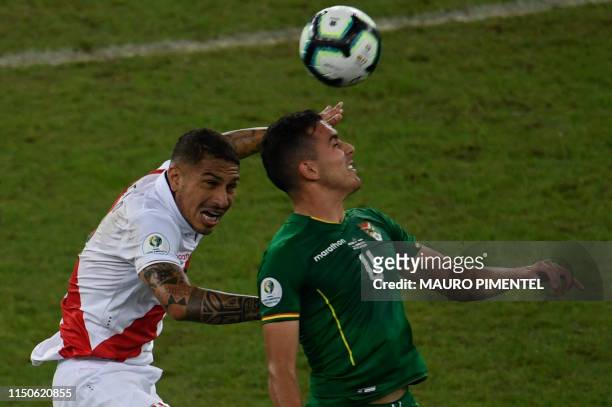 Peru's Paolo Guerrero and Bolivia's Luis Haquin jump for the ball during their Copa America football tournament group match at Maracana Stadium in...