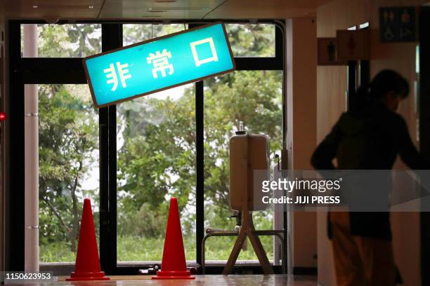 An emergency exit sign board hangs at an angle after nearly falling down during a 6.4 magnitude earthquake the night before, at a gymnasium in the...