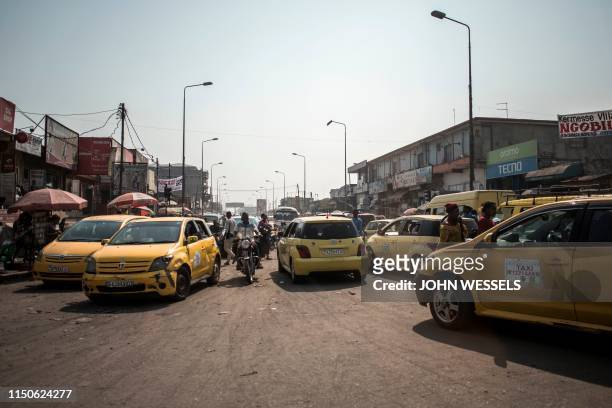 Yellow taxis clog up the streets of Kinshasa, capital of Democratic Republic of Congo on June 10, 2019. - Cities almost everywhere have transport...