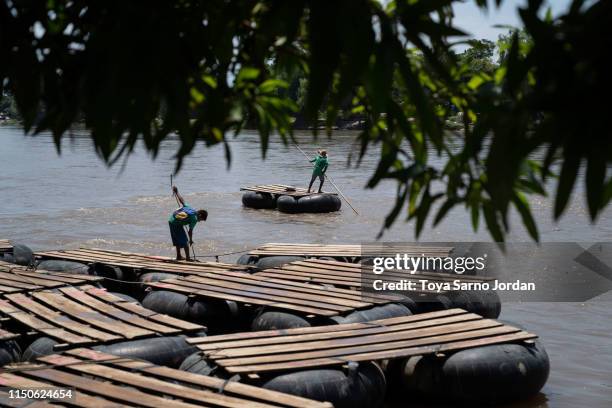 Young boys stand on rafts on June 18, 2019 on the Suchiate River in Ciudad Hidalgo in Chiapas, Mexico. The Mexican government launched a deployment...