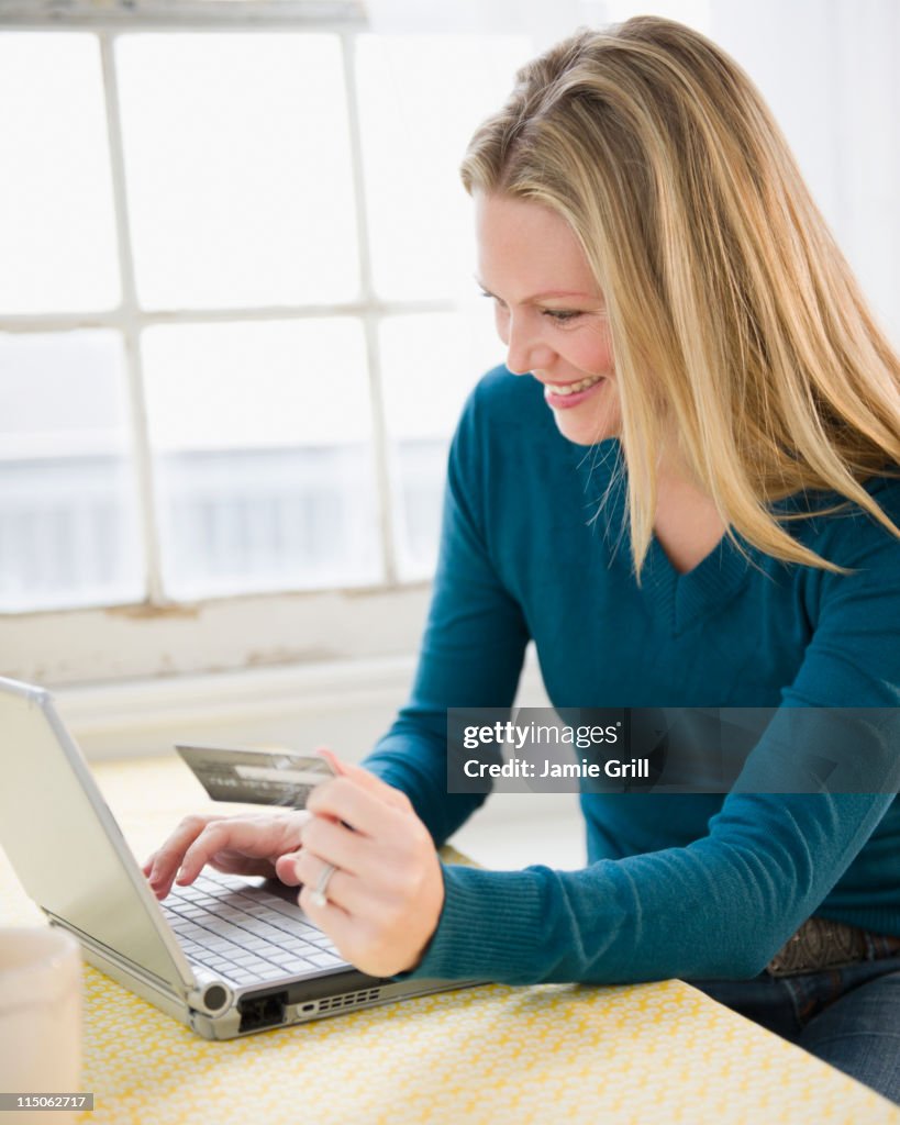 Woman using laptop with credit card