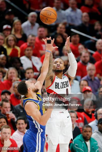 Damian Lillard of the Portland Trail Blazers shoots the ball against Stephen Curry of the Golden State Warriors during the second half in game four...