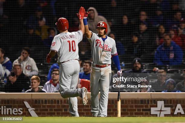 Realmuto of the Philadelphia Phillies is congratulated by Cesar Hernandez following a home run against the Chicago Cubs during the 10th inning at...