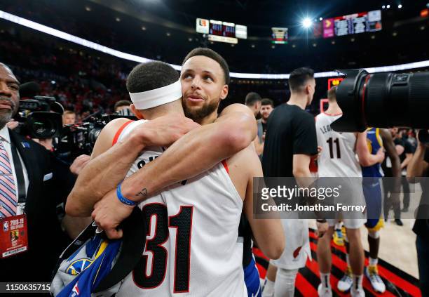 Stephen Curry of the Golden State Warriors hugs brother Seth Curry of the Portland Trail Blazers after defeating the Trail Blazers 119-117 during...
