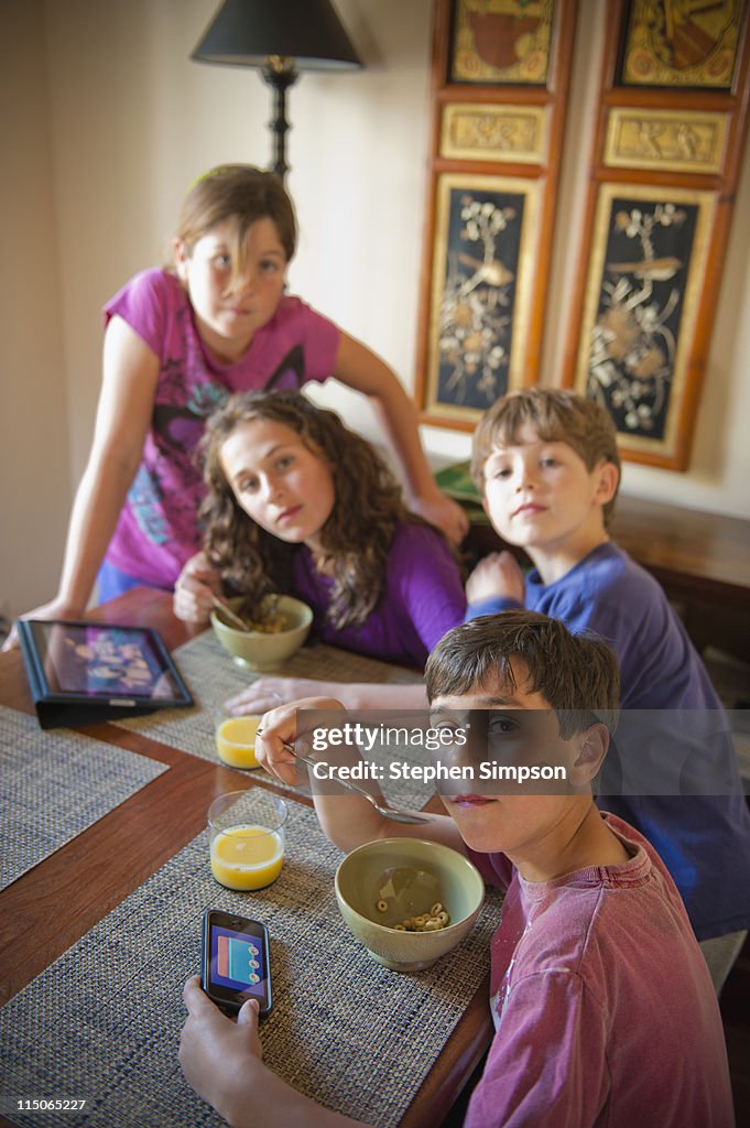 Kids playing computer games at the breakfast table