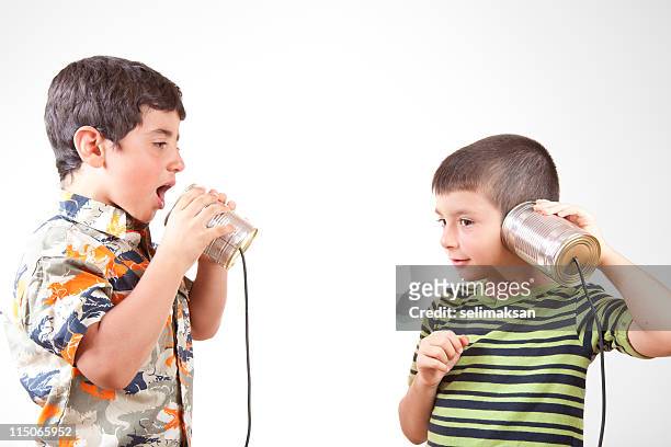 dos niños comunicar y hablando por teléfono de lata - tin can phone fotografías e imágenes de stock
