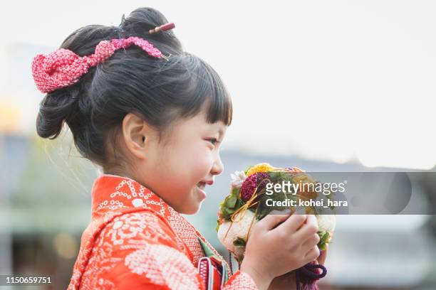 japanese girl wearing kimono holding round bouquet - shichi go san stock pictures, royalty-free photos & images