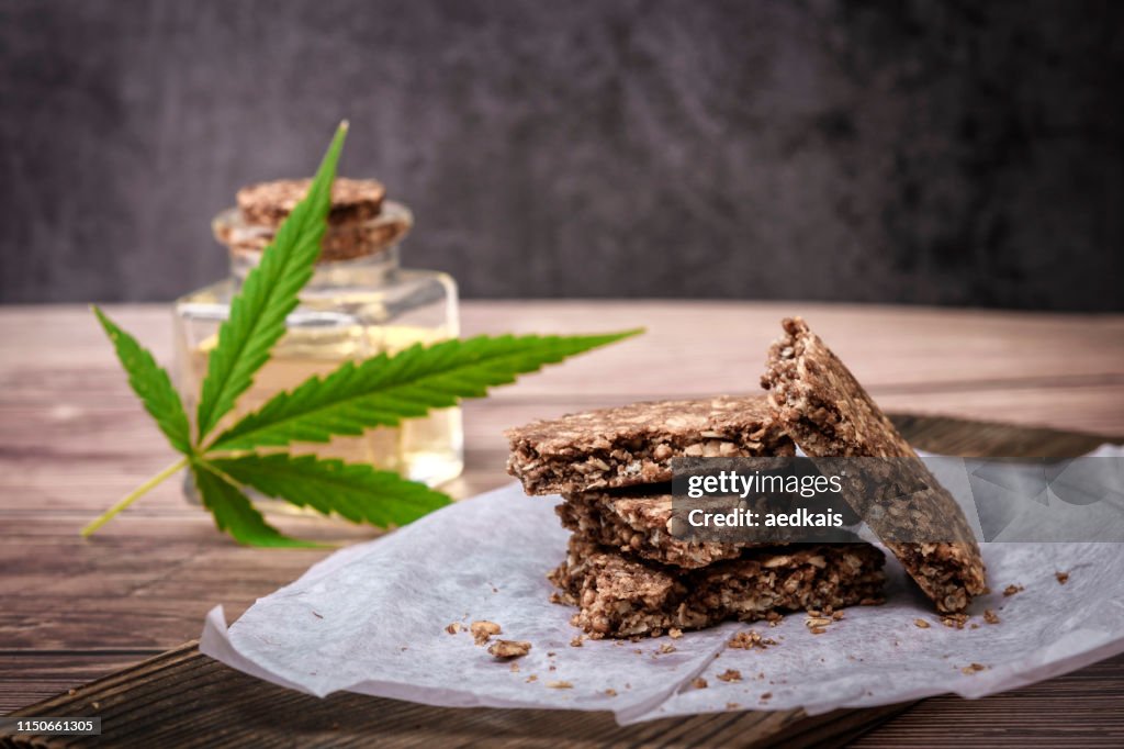 Marijuana leaf and cereal crunchy multigrain chocolate on brown wooden background.