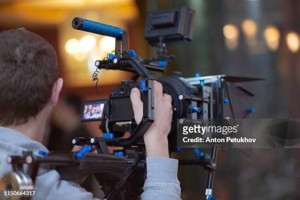 young male video cameraman, photographer, shoots video or takes a photo on the camera. - film director stock pictures, royalty-free photos & images