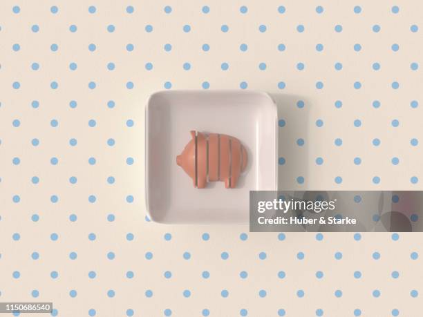 sliced piggy bank in plastic packaging on patterned table cloth - shared prosperity stock pictures, royalty-free photos & images