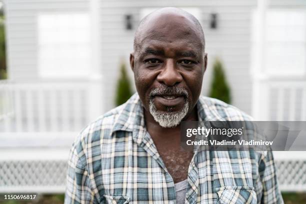 mature african man standing outdoors and looking at camera - 60 65 man stock pictures, royalty-free photos & images