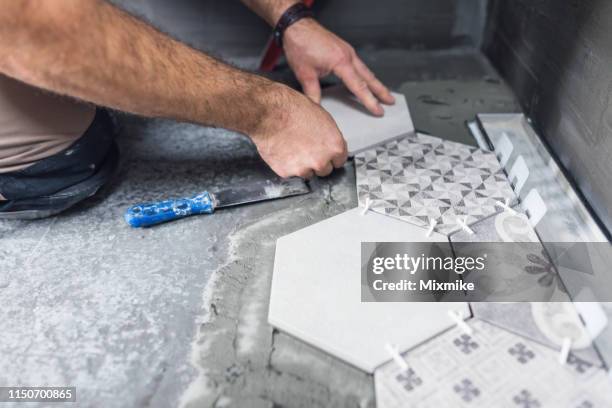 tiler laying ceramic tiles on the floor - tiler stock pictures, royalty-free photos & images